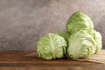 Fototapeta premium Fresh whole cabbages on wooden table. Space for text