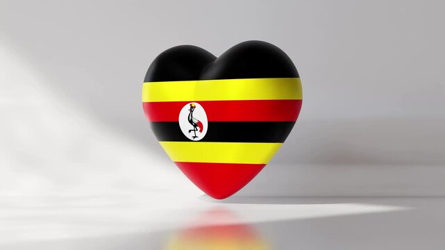 Heart shape spins in a loop with Uganda flag design. The animation shows bright colors in a seamless motion on a plain background. This creates an engaging visual
