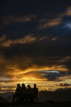 People marvelling at Montafon mountains with dramatic cloudy sky at sunset, Tschagguns, R&auml;tikon, Montafon, Vorarlberg, Austria