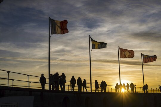 People, silhouettes, flags, harbour in Lindau am Lake Constance, Bavaria, Germany