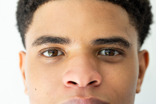 African American male in 20s gazing into camera in studio portrait showing eyes, skin texture