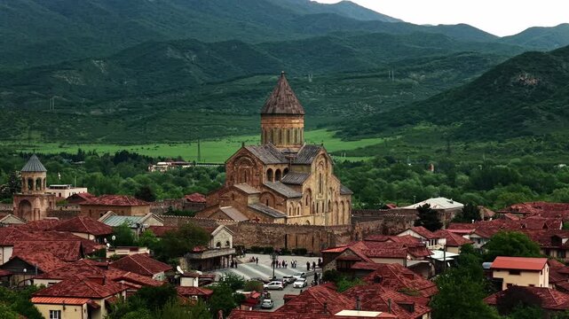 Cinematic aerial drone footage of the historic Svetitskhoveli Cathedral located in Mtskheta. One of the most important Orthodox landmarks in Georgia, surrounded by scenic landscapes 