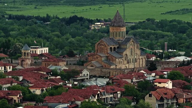 Cinematic aerial drone footage of the historic Svetitskhoveli Cathedral located in Mtskheta. One of the most important Orthodox landmarks in Georgia, surrounded by scenic landscapes 