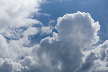Obraz premium Fluffy white cumulus clouds against a clear blue sky, natural weather background
