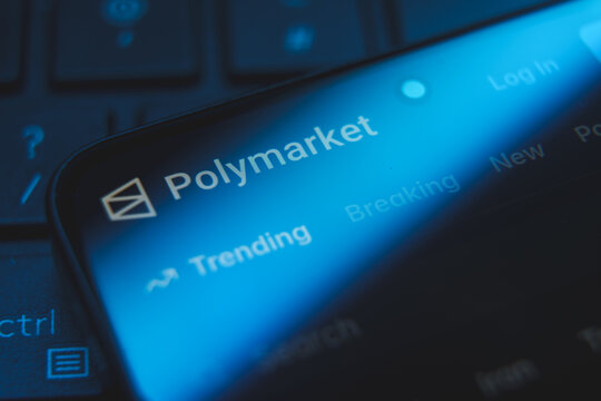 Polymarket website logo and interface displayed on a smartphone screen, decentralized prediction market platform for cryptocurrency betting and political forecasting concept