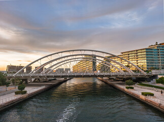 Fototapeta premium Modern Bridge Over Waterway at Al Raha Beach, Abu Dhabi, UAE During Sunset