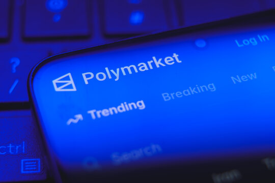Polymarket website logo and interface displayed on a smartphone screen, decentralized prediction market platform for cryptocurrency betting and political forecasting concept
