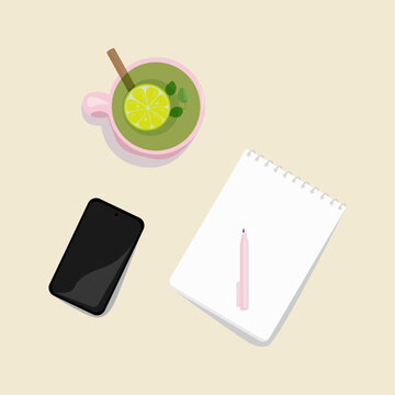On the desktop, there is a pink cup with healthy green tea with lemon, a notebook, a pen, and a phone. Learning concept, working from home