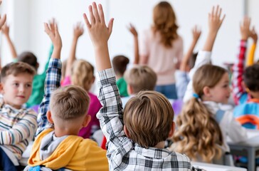 Fototapeta premium Diverse group of attentive elementary school children raising hands eagerly in classroom during lesson with teacher in background