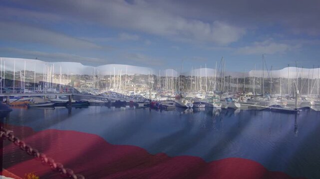 Light breeze causing crimson reflection rippling across marina, documenting calm moored sailboats