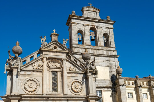 Baroque church facade with bell tower under blue sky