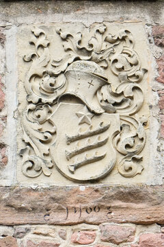 Medieval carved stone coat of arms on historic facade