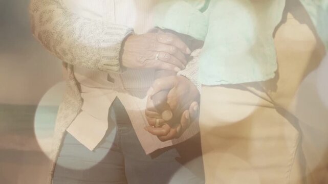 Woman and man walking shore, supporting hand initiating interlock for lifestyle bokeh showing rings