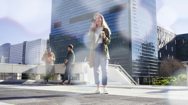 Woman on phone, sipping coffee while men tossing ball, sun causing lens flare overlay for ads