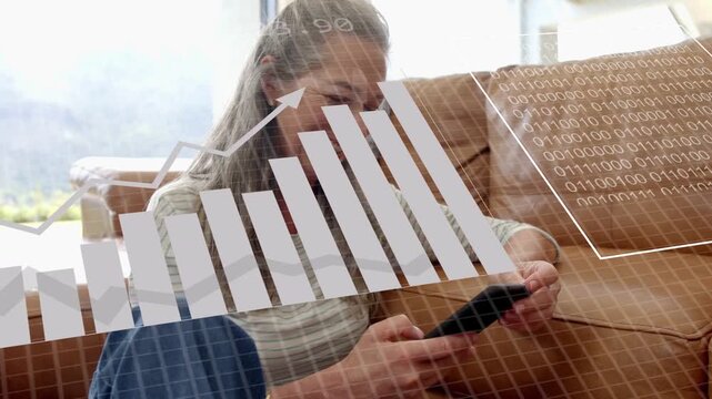 Senior woman tapping cell on sofa activating tech HUD showing rising bars binary collecting data