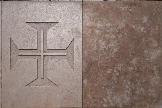Carved Templar cross detail on aged stone wall