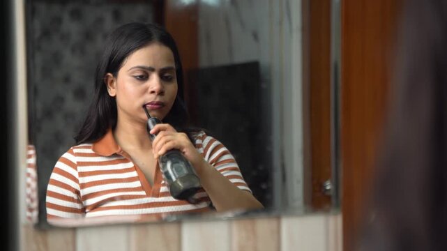 Indian Woman Using Water Flosser for Oral Care and Dental Hygiene at Home