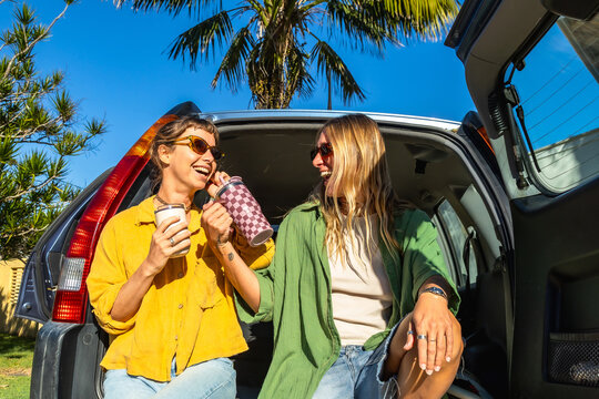 Surfing friends laughing in car trunk during australian road trip