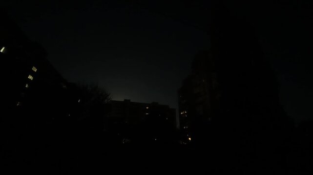 Blackout in the city, full moon behind the buildings, time lapse till sunrise