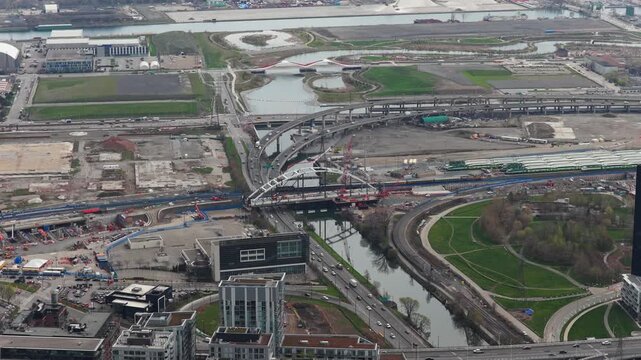 High angle of Toronto's Port Lands with the Don River flowing under Cherry Street bridge and Gardiner Expressway with city traffic moving across urban landscape