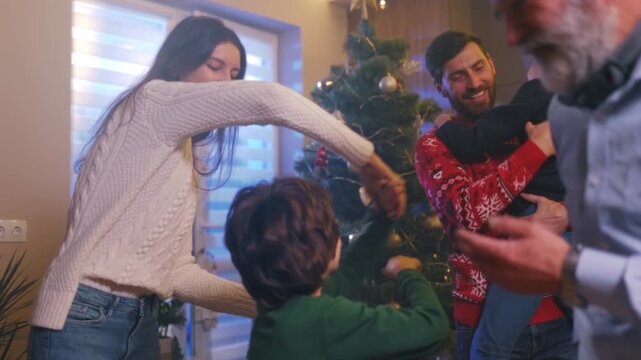 Family festive fun, Warm family gathering immersed in playful interactions beneath sparkling holiday decorations