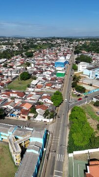Vista a&eacute;rea de avenida urbana cercada por bairros residenciais destaca mobilidade e crescimento urbano brasileiro.