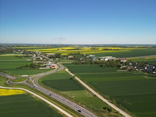 Województwo Świętokrzyskie - Polska - pola rzepaku w rozkwicie, piękny żółty kolor i krajobraz wiejski zdjęcie wykonane dronem z powietrza. Rzepak, pola, drogi, niebo, krajobraz wiejski © Konrad