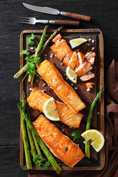 fried salmon with asparagus and lemon on a board