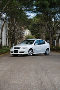 White Chevrolet Astra GSI front view three quarters, Classic hot hatch in tree lined street