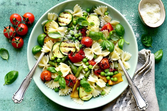 Traditional italian pasta primavera with spring vegetables. Top view with copy space.