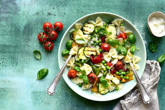 Traditional italian pasta primavera with spring vegetables. Top view with copy space.