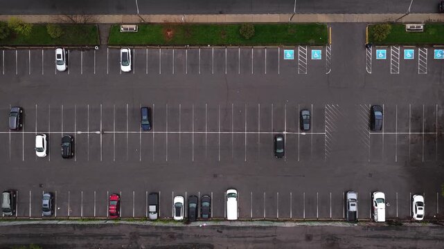 Cars parked in parking lot, overhead showing urban traffic patterns and availability of spots in North American city during a cloudy day