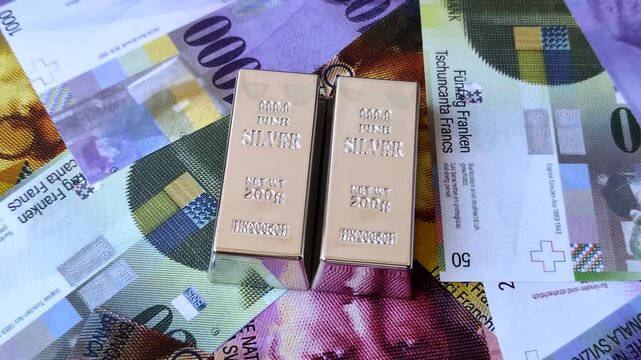 A silver bar, white metal against a backdrop of Swiss flag, as a concept for the sales market. A silver bar as a background for your design