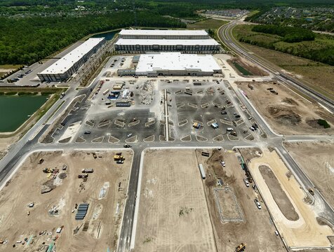 Aerial view of the Foundry Lane industrial construction site featuring large warehouses and expansive parking lots under development in World Golf Village, Florida, United States.