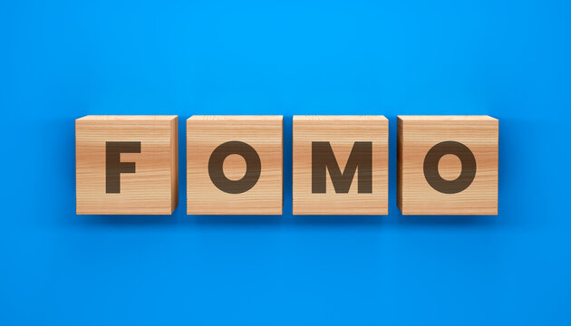 FOMO Block Letter: Wooden blocks spell out FOMO against a vibrant blue backdrop. A concept of the fear of missing out, a modern phenomenon that grips societies.
