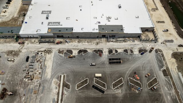 Aerial view of Foundry Lane construction site featuring a large industrial building with a white roof and a developing parking area World Golf Village, Florida, United States.