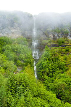 Devils Chimney Waterfall dropping through misty cliffs near Glencar Lough, Ireland. Dramatic cascade in the lush northwest landscape of County Sligo and Leitrim.