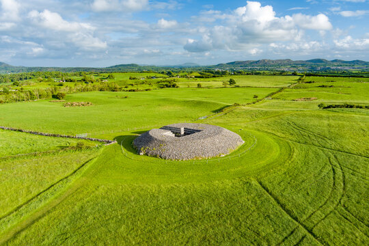 Aerial view of Carrowmore Passage Tomb surrounded by bright green fields in County Sligo, Ireland. An ancient megalithic monument in the Irish countryside.