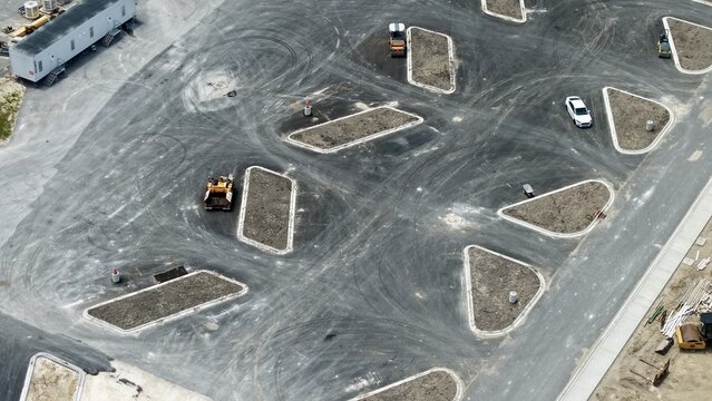 Aerial view of construction progress at Foundry Lane featuring heavy machinery and geometric road islands in World Golf Village, Florida, United States.