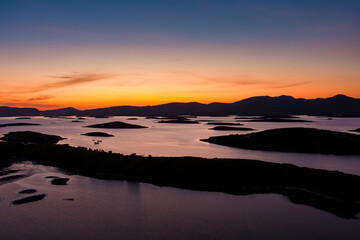 Naklejka premium Aerial sunset view over Clew Bay near Westport, County Mayo, Ireland. Scenic Atlantic bay with drumlin islands and mountain silhouettes on the Wild Atlantic Way.