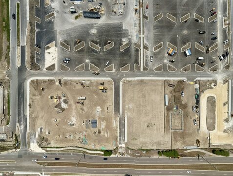 Aerial view of the construction site at Foundry Lane featuring a new parking lot layout, heavy machinery, and dirt ground in World Golf Village, Florida, United States.