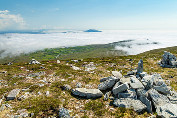 Naklejka premium Mountain view from Minaun Heights on Achill Island, County Mayo, Ireland. Scenic rocky summit landscape above clouds, coast and Atlantic islands.