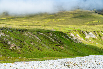 Naklejka premium Southern Keel Beach on Achill Island, County Mayo, Ireland, with a pebble shore beneath dramatic sea cliffs. This image shows the rugged coastal edge of the beach from ground level.