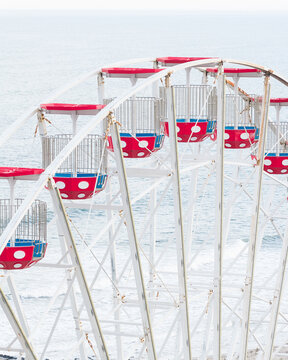 Aerial view of a white Ferris wheel with red polka dot gondolas overlooking the ocean waves Ocean City, New Jersey, United States.