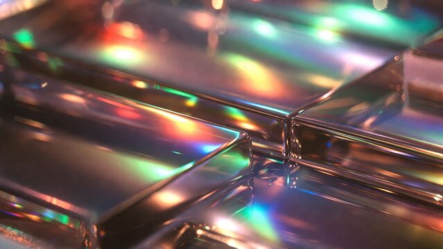 Stacked glass tiles scattering colorful light on reflective surface