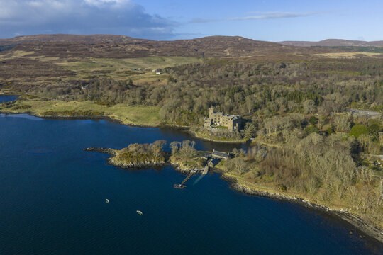 Aerial view of Dunvegan Castle and Gardens on the shore of Loch Dunvegan surrounded by lush woodlands and rolling hills Isle of Skye, Scotland, United Kingdom.