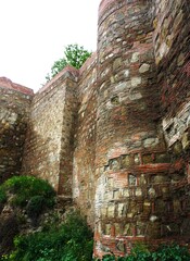 Z bliska widać wysokie, masywne mury twierdzy Narikala w Tbilisi, zbudowane z surowego kamienia o wyraźnej, historycznej fakturze. © Adam