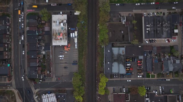 Top down aerial perspective showing train tracks separating two distinct districts in downtown Toronto, with vehicles moving through busy streets and intersections
