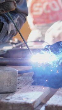 Closeup Arc Welding Pipe Joint, Bright Blue Arc Illuminates Bench And Welding Machine As Gloved Hands Steady Electrode And Sparks Spray, Emphasis On Intense Light And Focused Metalwork.