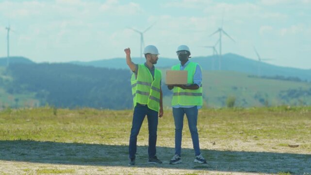 Engineers collaboratively monitor and manage wind energy project schedules and resource deployment for sustainability